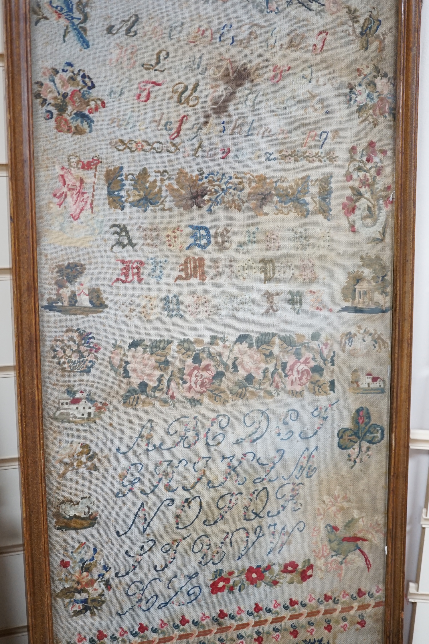 Two mid 19th century embroideries; a framed sampler dated 1809 and an embroidered figurative panel, largest 114 x 42cm. Condition - poor